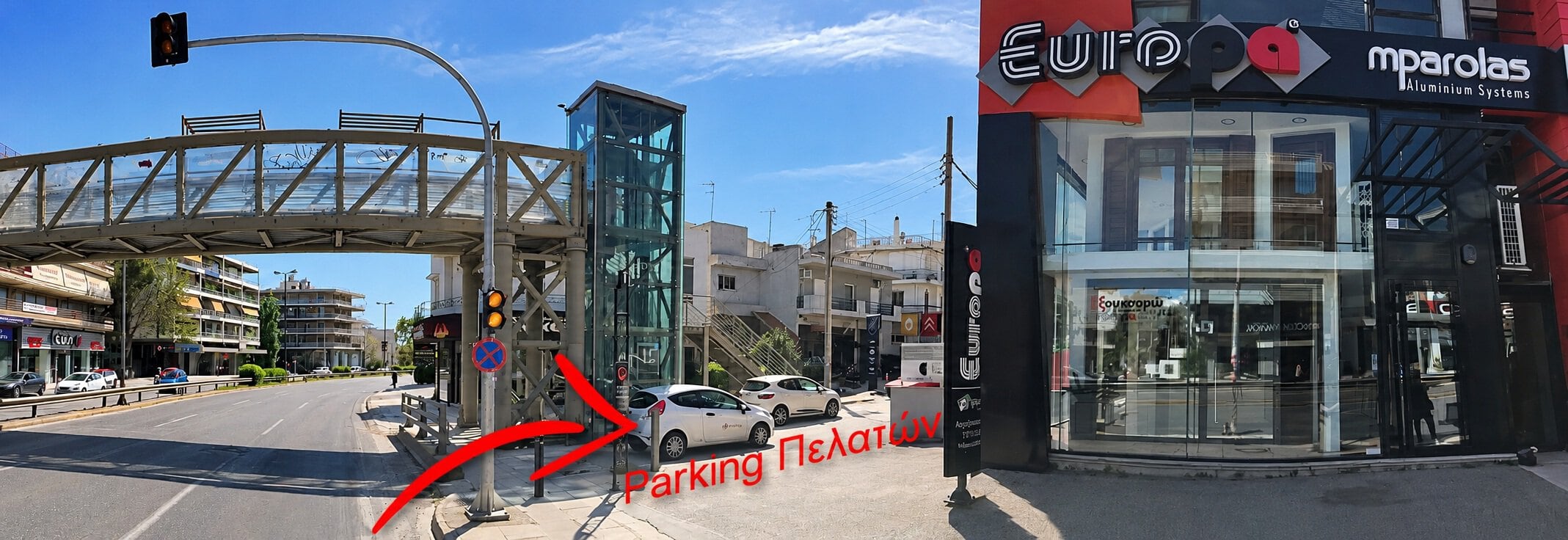 Πρόσβαση στο parking πελατών της έκθεσης Europa Mparolas στη Λεωφόρο Κηφισίας 157, Μαρούσι, με πεζογέφυρα, κτίριο και ορατή σήμανση κατεύθυνσης