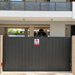 Modern anthracite sliding aluminium garage gate TR55 installed at residential building